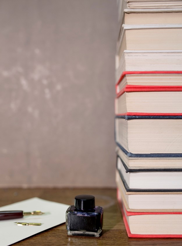 ink-bottle-near-stack-books_23-2147767246