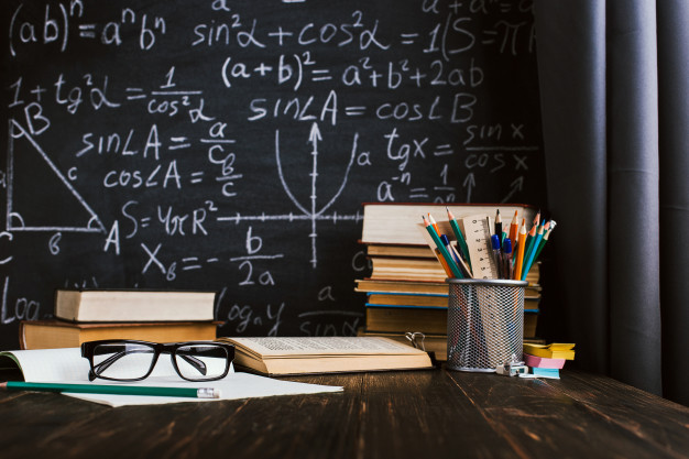 school-desk-classroom-with-books-background-chalk-board-with-written-formulas_89381-136